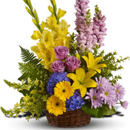 Mixed flower basket with yellow lilies, purple roses, and pink snapdragons