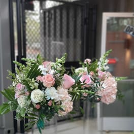 Pink and white floral arrangements in tall clear glass vases