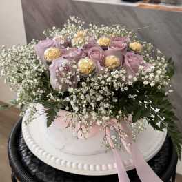 Pink roses with baby’s breath and chocolates in a white hat box