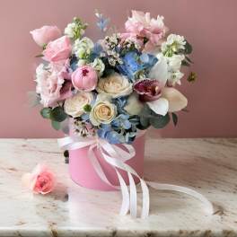 Pink and blue bouquet in a pink hatbox with a white ribbon