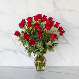 Red roses arranged in a clear glass vase