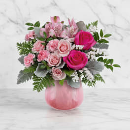 Pink roses and alstroemeria in a pink glass vase