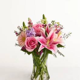 Pink roses and lilies in a clear glass vase