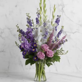 Purple and white mixed bouquet in a clear glass vase