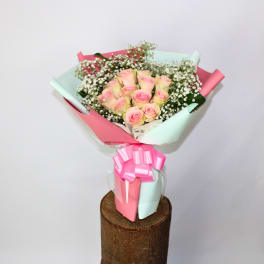 Bouquet of pink roses wrapped in pastel pink and mint paper
