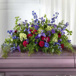 Large casket spray with blue, purple, pink, and white flowers