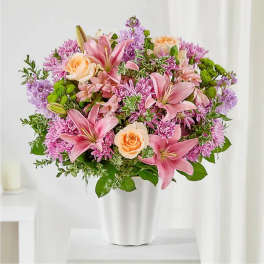 Pink lilies and peach roses in a white vase
