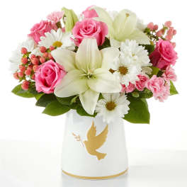 Pink roses and white lilies in a white vase with a gold dove design