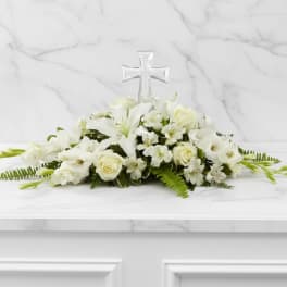 White floral arrangement with a clear cross centerpiece