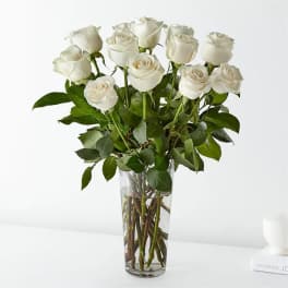 White roses arranged in a clear glass vase