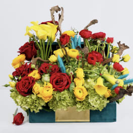 Bright mixed bouquet with red roses and yellow calla lilies in a teal box