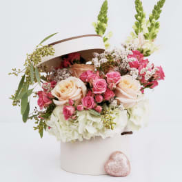 Pink and cream roses in a white hatbox with a glittery heart