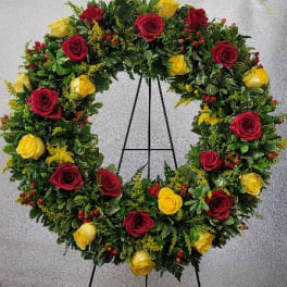 Heart-shaped wreath of red and yellow roses on an easel
