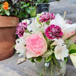 Pink rose and white lily bouquet in a glass vase