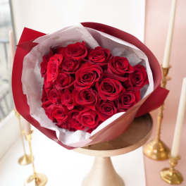 Bouquet of red roses wrapped in red and white paper