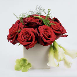 Red roses in a beige box with pale calla lilies