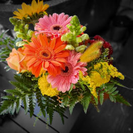 Bright mixed bouquet with gerbera daisies, roses, and yellow filler flowers