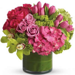 Pink roses, tulips, and hydrangea in a green glass vase