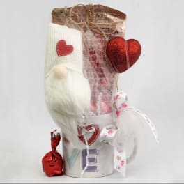 Gift basket with a white plush toy, red heart decorations, and a small wrapped candy