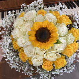 Bouquet of yellow and white roses with a sunflower center