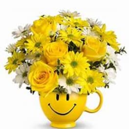 Yellow flowers arranged in a smiley-face mug