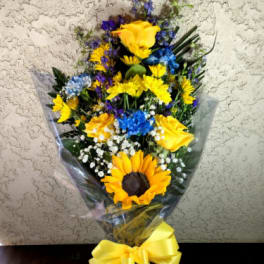 Bouquet of yellow sunflowers and blue flowers wrapped with a yellow ribbon