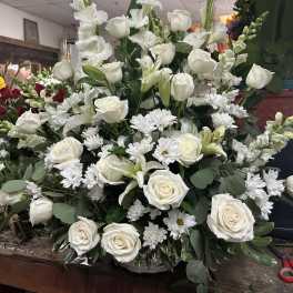 Large white floral arrangement with roses, lilies, and daisies
