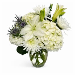 White lilies and chrysanthemums in a clear glass vase