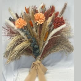 Dried flower bouquet with orange blooms and pampas grass tied with ribbon