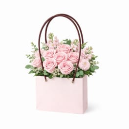 Pink roses and small pink flowers in a pale pink gift bag