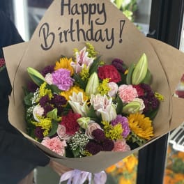 Mixed bouquet with a Happy Birthday sign and brown paper wrap