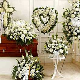 White funeral floral sprays and wreaths around a casket