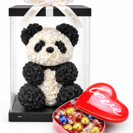 Panda-shaped rose arrangement in a clear display box with a heart candy tin