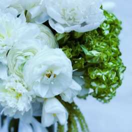 White bouquet with peonies and green hydrangeas tied with a white ribbon