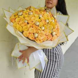 Large bouquet of yellow and peach roses with gold accents