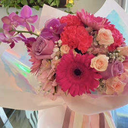 Pink and purple bouquet with gerbera daisies, roses, and orchids