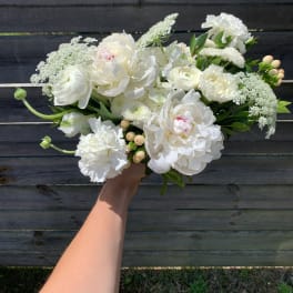 White bouquet of peonies, ranunculus, and carnations with laceflower accents