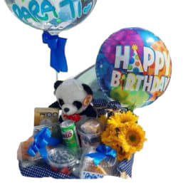 Birthday gift basket with balloons, a teddy bear, snacks, and sunflowers