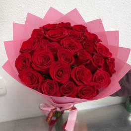 Bouquet of red roses wrapped in pink paper