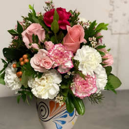 Pink and white mixed flower arrangement in a painted ceramic vase