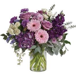 Bouquet of pink, purple, and white flowers in a clear glass vase