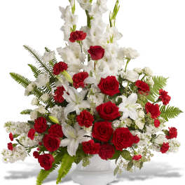 Red roses and white lilies arranged in a white vase