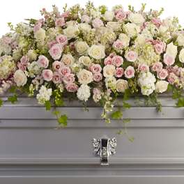 Pastel rose and hydrangea casket spray on a silver casket