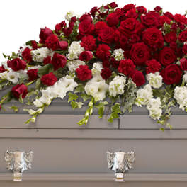 Red and white floral casket spray on a gray casket