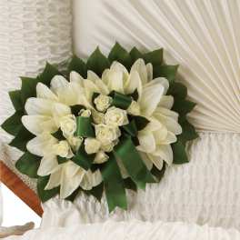 White floral bouquet with green ribbon accents on a white chair