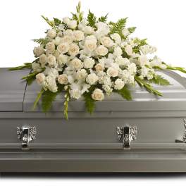 White floral casket spray on a gray casket