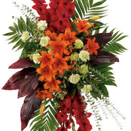 Tall standing floral spray with red and orange flowers on a metal easel