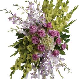Tall floral spray with pink roses and lavender orchids on a white stand