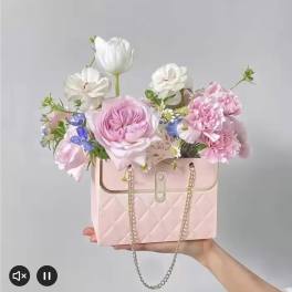 Pink floral arrangement in a quilted handbag-shaped box