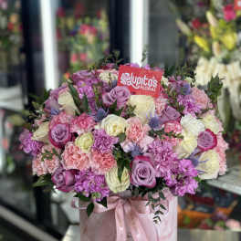 Pink and lavender rose bouquet in a round gift box with a ribbon